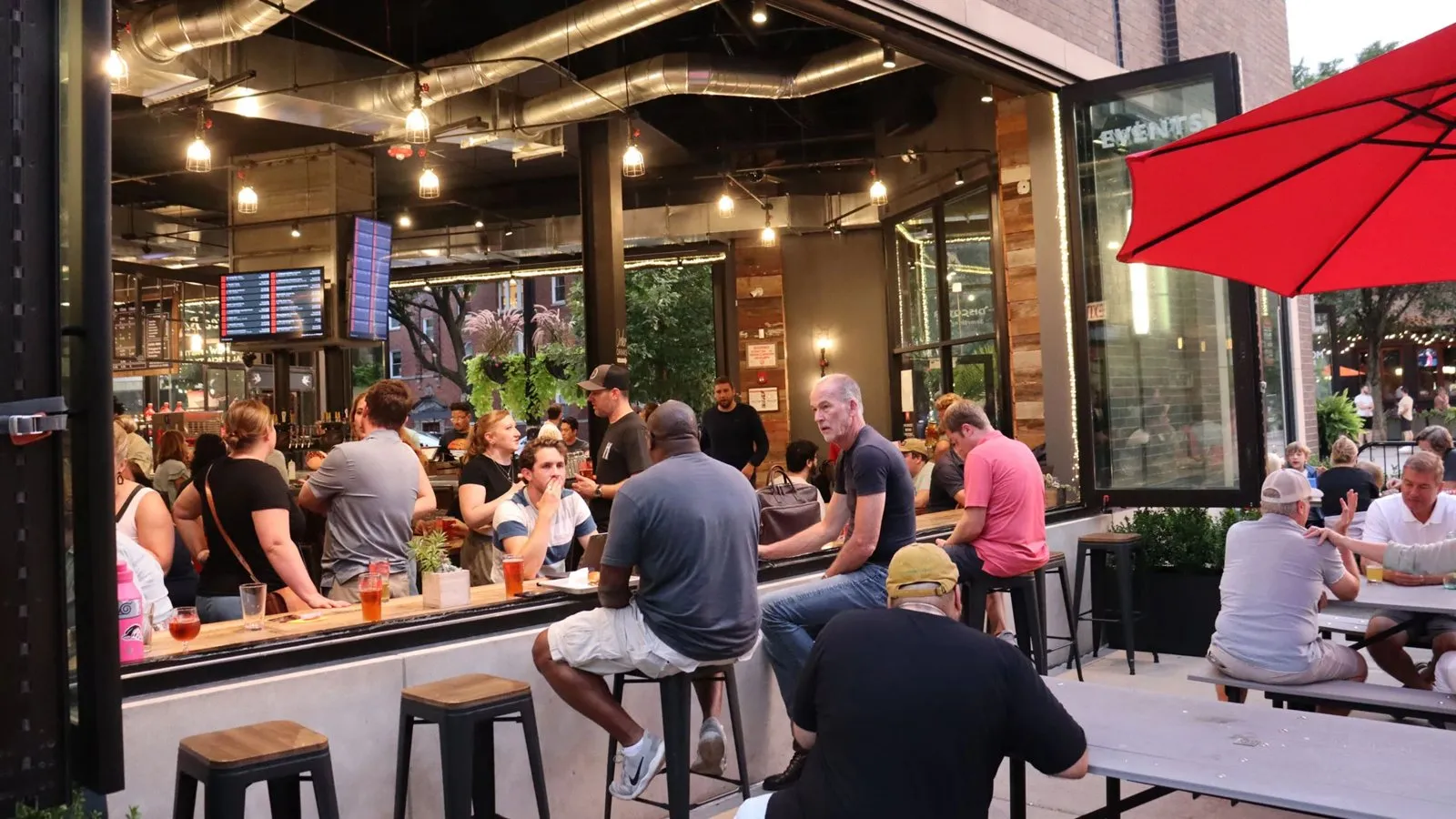 Guests seated around the open windows and patio at Bitter Pops